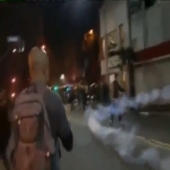 Manifestante chutando bomba de volta
